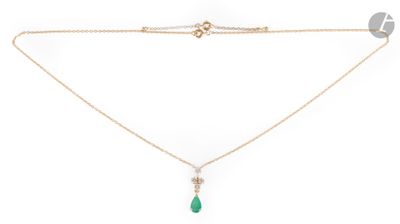 a gold necklace with a green tear pendant and a chain