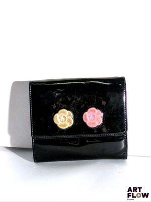 un sac à main noir orné de deux fleurs roses et jaunes