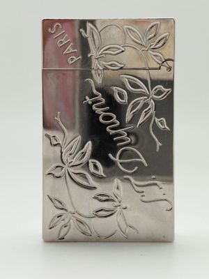 une image représentant un briquet argenté orné d'un motif de feuilles