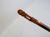 quelqu'un tient un bâton en bois sur lequel est sculpté un homme