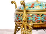a gold and blue bowl on a stand on a table