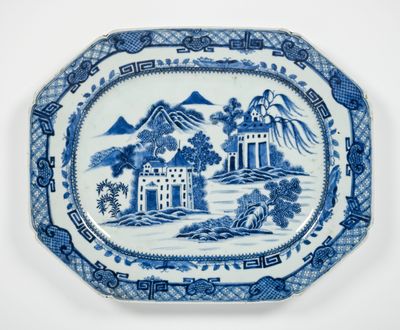 une assiette bleue et blanche ornée d'un paysage
