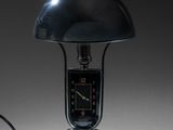 une lampe posée sur une table sur laquelle se trouve une horloge