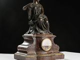 a statue of a woman sitting on top of a clock