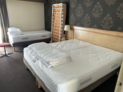 deux lits dans une chambre avec une échelle dans un coin