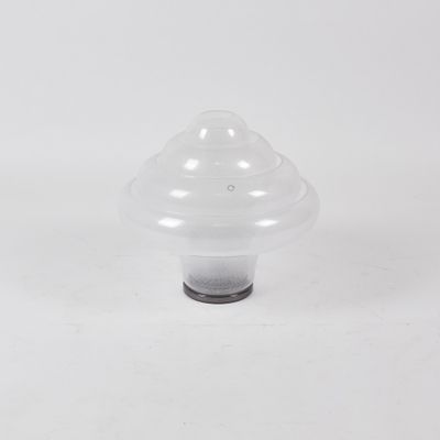 un gros plan d'un objet en plastique en forme de champignon posé sur une surface blanche