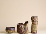 trois pièces de poterie posées sur une table blanche