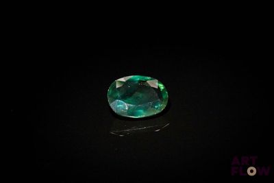 des pierres précieuses vert émeraude sur un fond noir