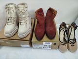 trois paires de chaussures posées sur une boîte