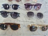 many pairs of sunglasses on display on a table