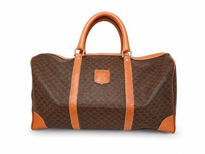 a brown and tan duffel bag sitting on top of a white surface