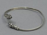 a close up of a silver bracelet with two skulls on it