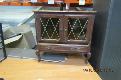 a small wooden cabinet with glass doors on top of a table