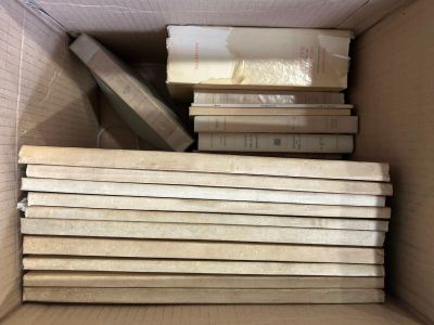 a lot of books in a cardboard box on the floor