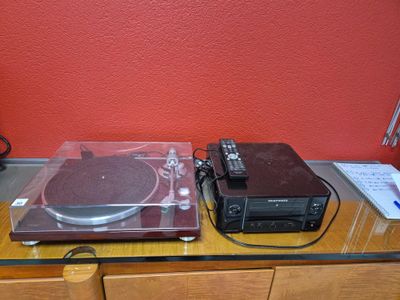 un tourne-disque et une platine posés sur une table en verre