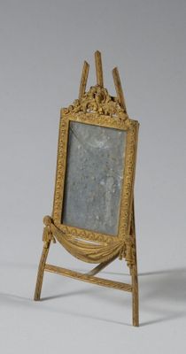 a gold frame with a picture on it on a stand