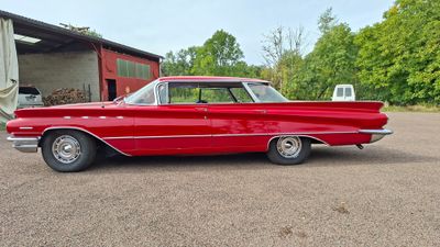 a red car parked in a parking lot next to a building