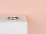 une photo d'une bague en diamant posée sur un bloc