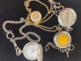 three different types of pocket watches on a black surface