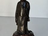 une statue représentant une femme assise sur un rocher