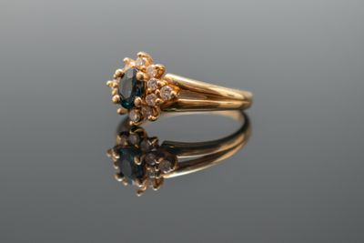 un gros plan d'une bague en or sertie d'un diamant bleu