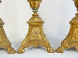 three gold candlesticks sitting next to each other on a table