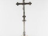 a silver cross on a stand with a rope around it