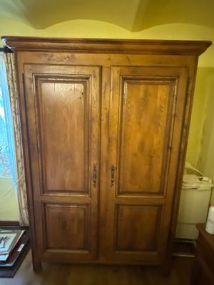 une grande armoire en bois dans le coin d'une pièce