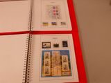 a red book with two pages of stamps on top of it