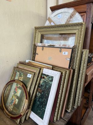 a lot of framed pictures on a shelf in a room