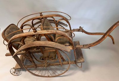 an old fashioned wooden carriage that is sitting on a white surface