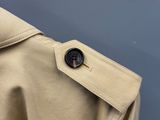 le dos d'un trench-coat beige orné d'un bouton
