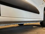 a white truck parked in a garage with a flat tire