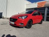 une voiture rouge garée devant un immeuble, sur un parking