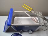 a metal container with a blue handle and a yellow handle