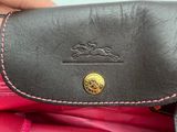 a person holding a pink purse with a black handle