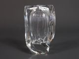 un vase en verre transparent posé sur une surface noire