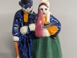a figurine of two people sitting on a bench