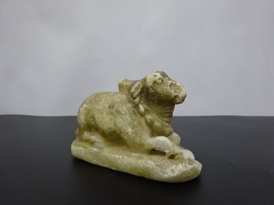 statue of a sheep on a rock on a black surface