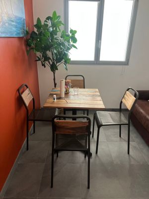 a table and chairs in a small room with a large window