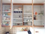 many dishes and glasses in the cupboards of this kitchen