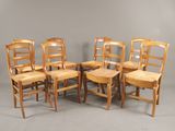 six chaises en bois sont alignées en rang contre un mur gris