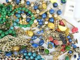 many different colored beads and chains on a white surface
