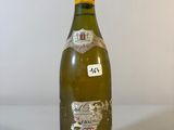 une vieille bouteille de vin posée sur une table blanche