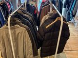a lot of clothes hanging on a rack in a store