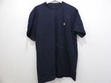 a black t - shirt hanging on a hanger against a white wall