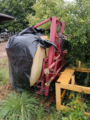 un tracteur qui est garé dans l'herbe, avec un sac posé dessus