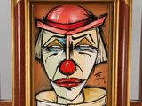 un tableau représentant un clown coiffé d'un chapeau rouge, posé sur un chevalet