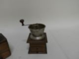 a silver cup on a wooden stand next to a coffee grinder
