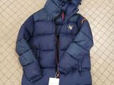 a close up of a blue down jacket on a tiled floor